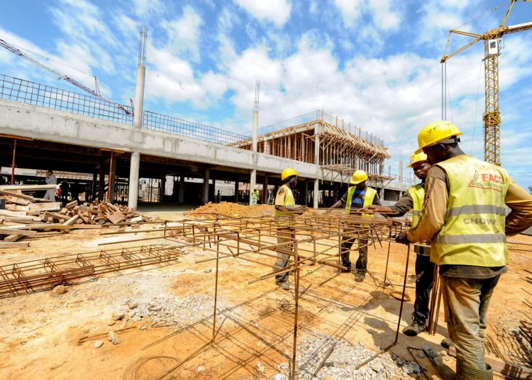 Workers work on the construction of a university hospital in Owendo, port of Libreville on October 11, 2012. Gabon has launched a 20 billion USD infrastructure investment plan, which aims to make the country an emerging country by 2025. AFP PHOTO / STEVE JORDAN        (Photo credit should read Steve Jordan/AFP/GettyImages)