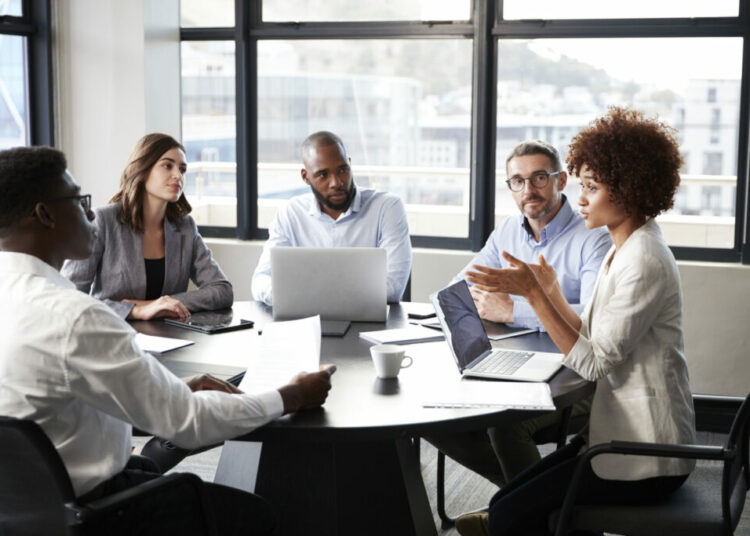 Millennial black businesswoman addressing colleagues at a corporate business meeting, close up